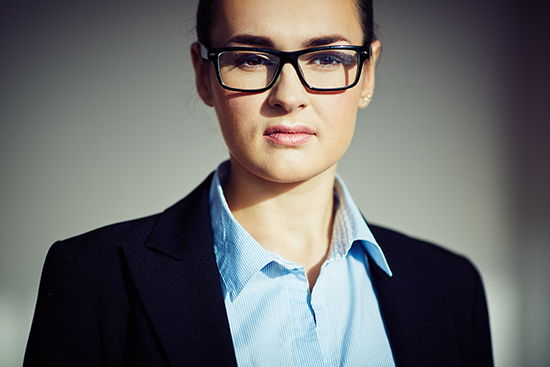 Serious formally dressed businesswoman in eyeglasses